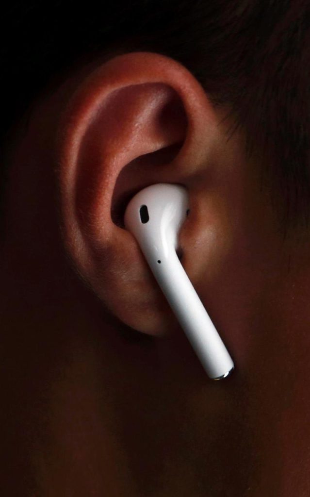 An attendee wears the Apple AirPods. CREDIT: REUTERS