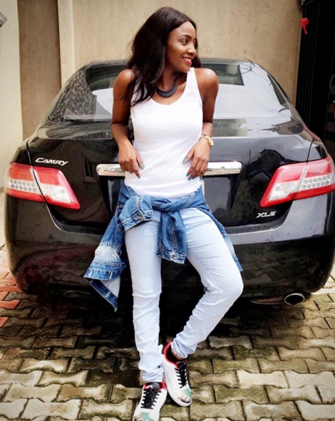 Simi posing next to Adekunle Gold's car