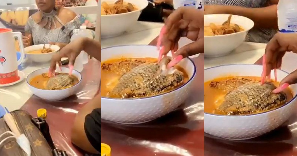 Moment lady struggles to eat fish with long artificial nails (Video)
