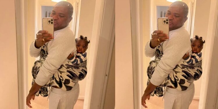 “UK will humble you” – Nigerian man says as he backs his child while wife is at work