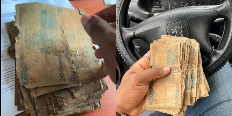 Nigerian man shows the N200 notes given to him at the bank (Photos)