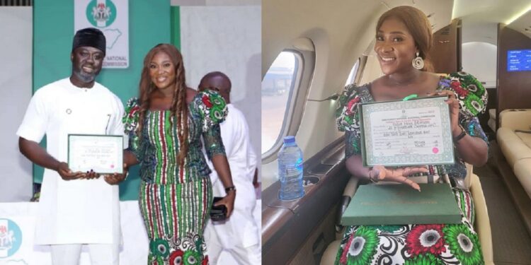 HOR member-elect, Odiasen Okojie dedicates his certificate of return to his wife, Mercy Johnson