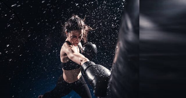 Young woman boxing at the punching bag