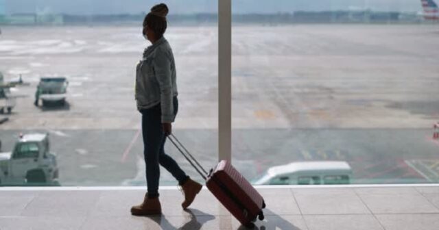 Mature african woman wearing safety face mask inside airport